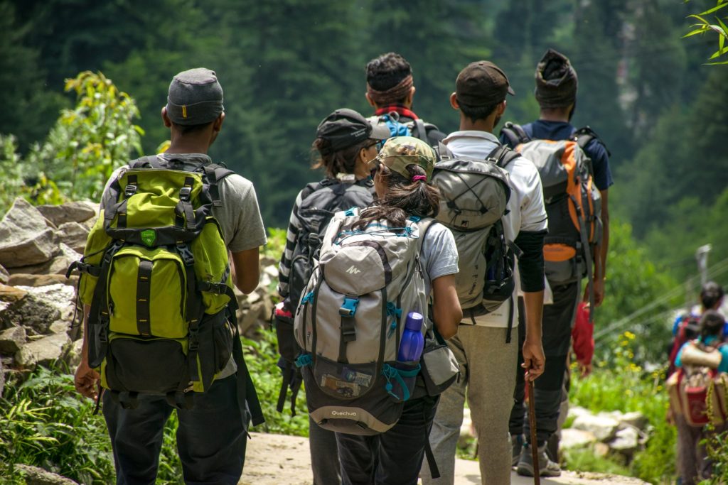 Group of men and women hiking on trail with backpacks