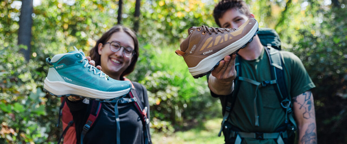Two people outdoors holding shoes