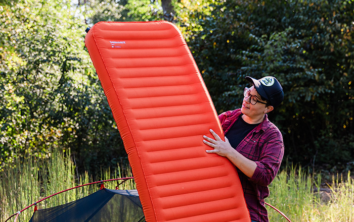 woman camping with sleeping pad
