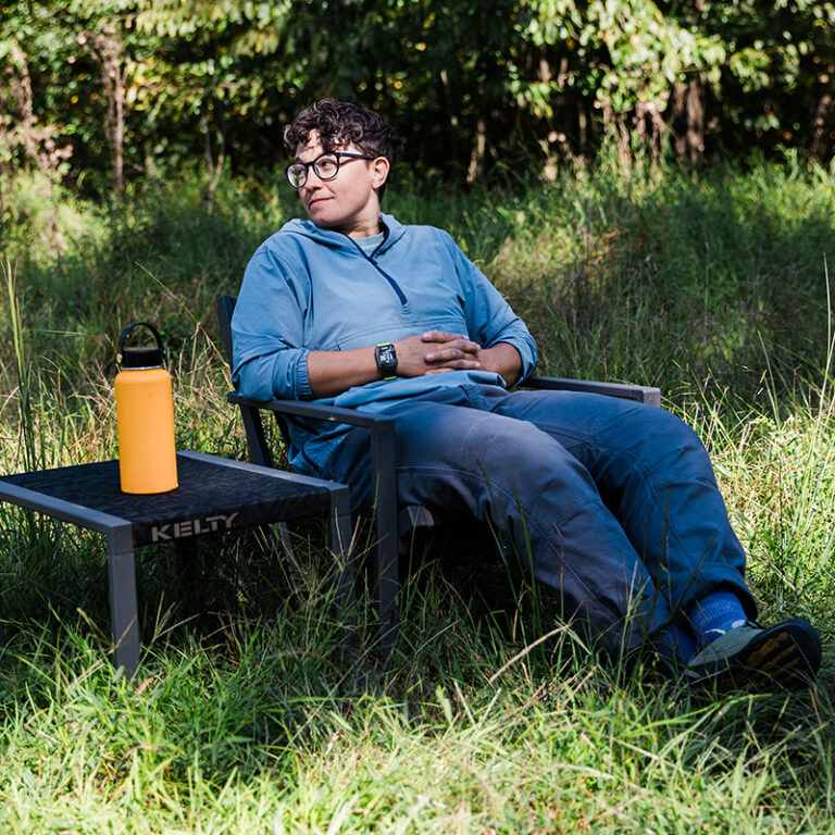 person sitting outdoors in camp chair