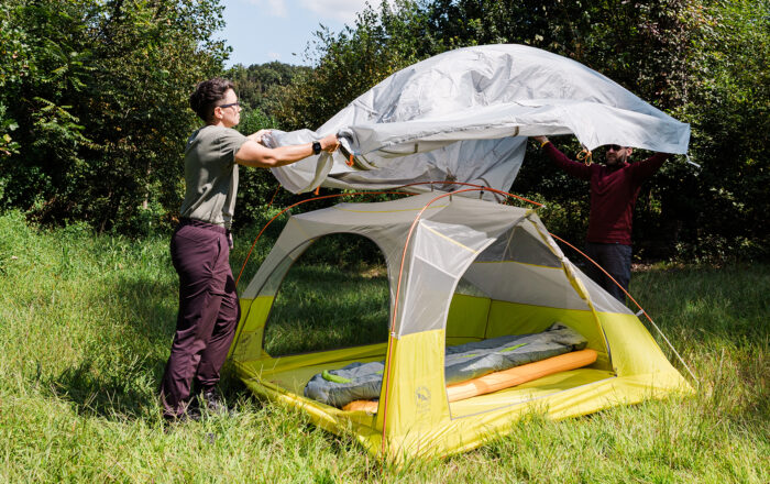 Person setting up tent at campsite