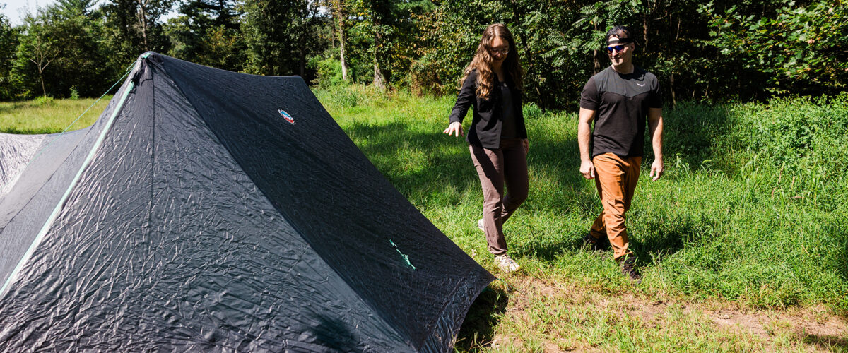 two people with backpacking tent outdoors