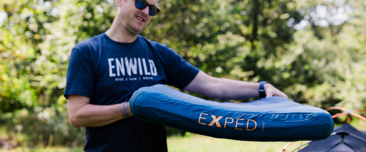 man outdoors holding sleeping pad