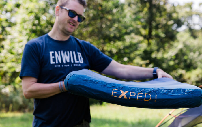 man outdoors holding sleeping pad