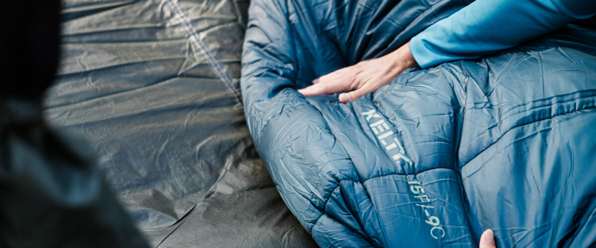 Person camping with Kelty sleeping bag