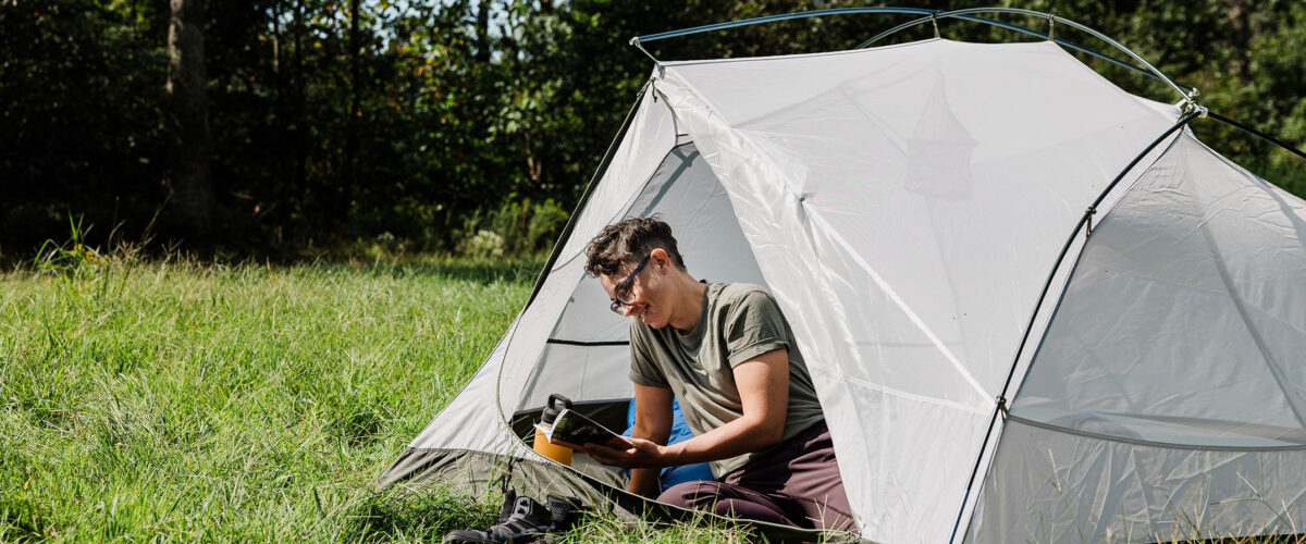 person outdoors camping in tent