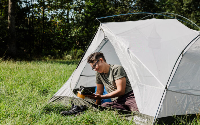 person outdoors camping in tent