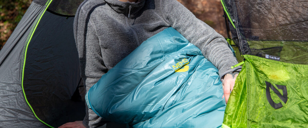 woman camping with NEMO sleeping bag