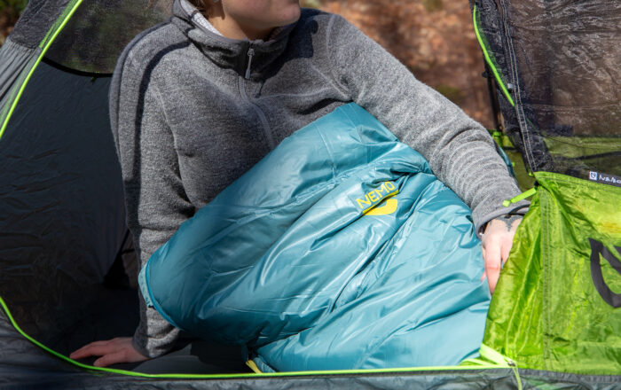 woman camping with NEMO sleeping bag