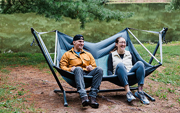 two people outdoors in camp chair