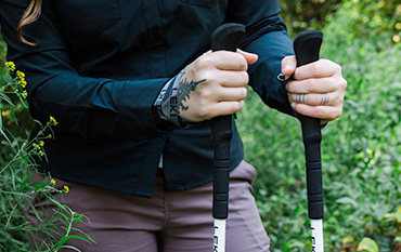 closeup of person outdoors using trekking poles