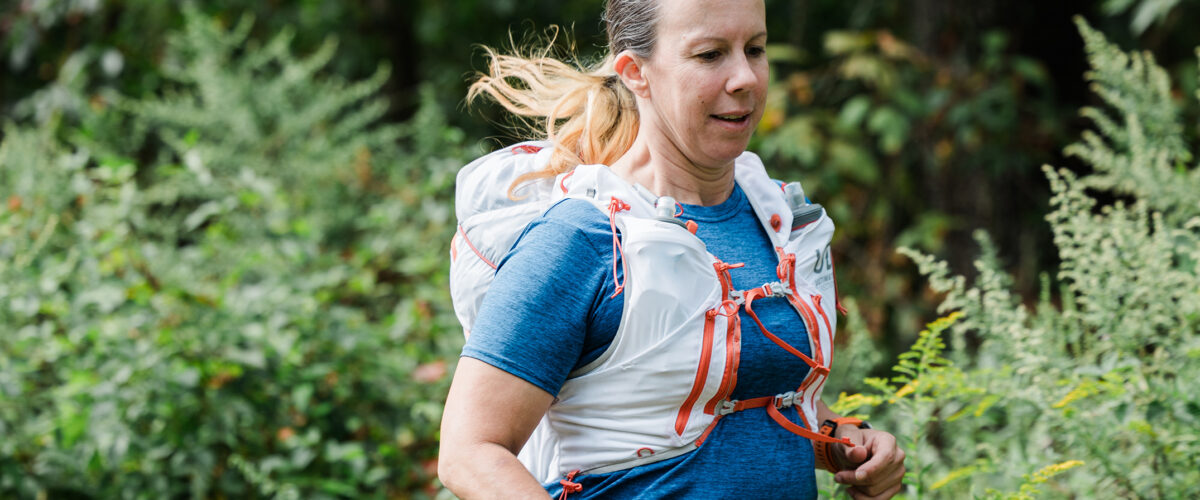 woman running outdoors with Ultimate Direction Adventure Vest 17