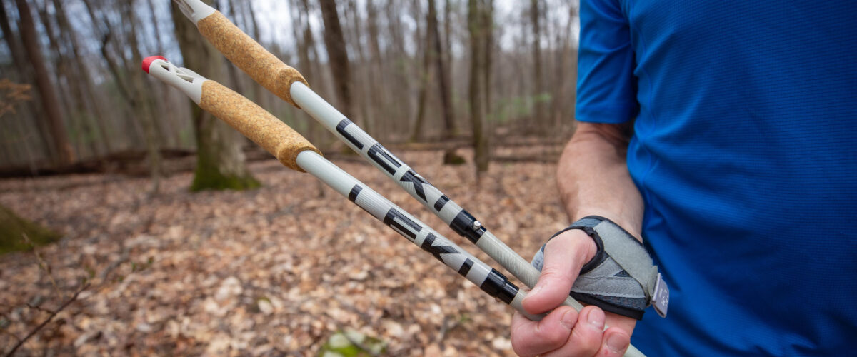 close up of person holding trekking poles outdoors