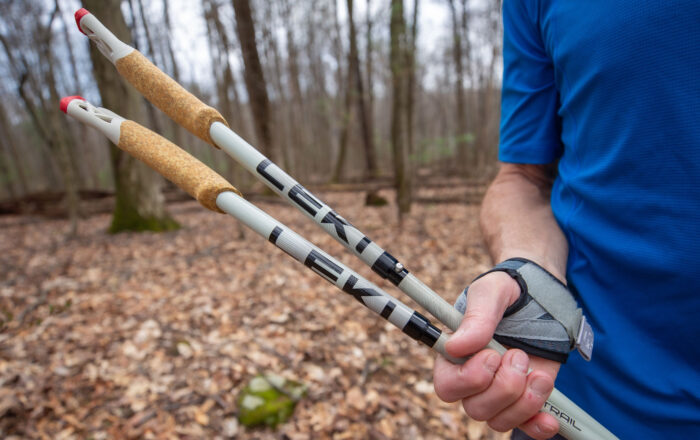 close up of person holding trekking poles outdoors