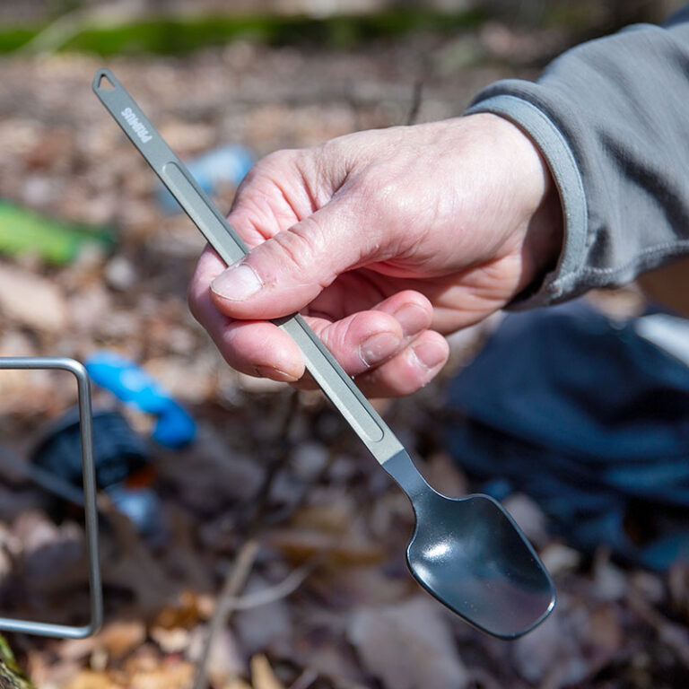 person holding spoon at campsite