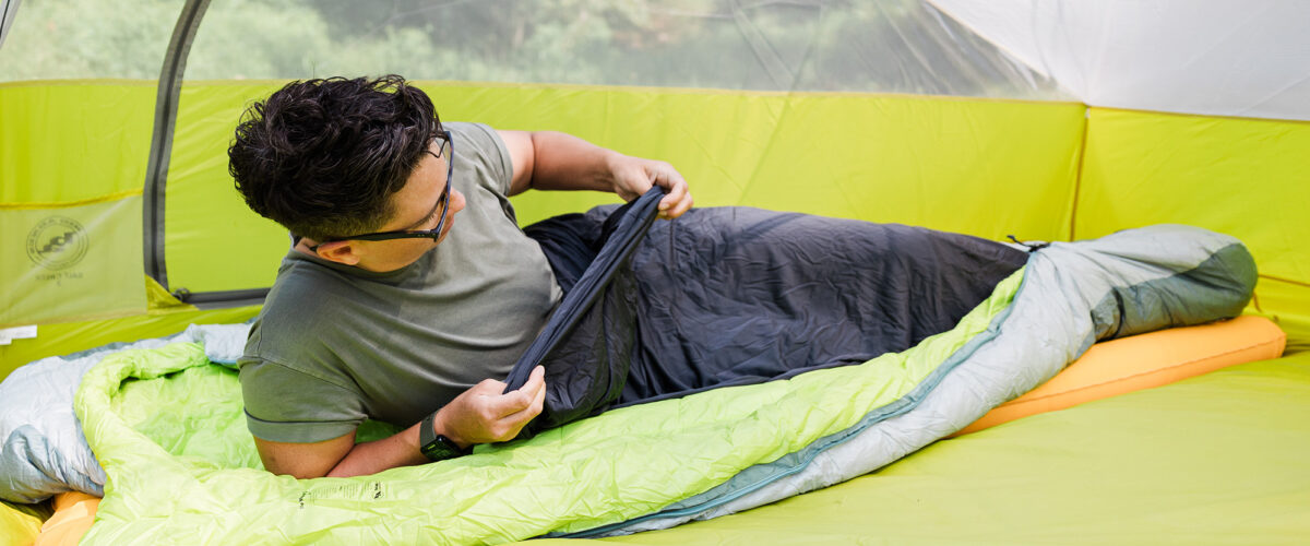 Person camping with Big Agnes sleeping bag and liner