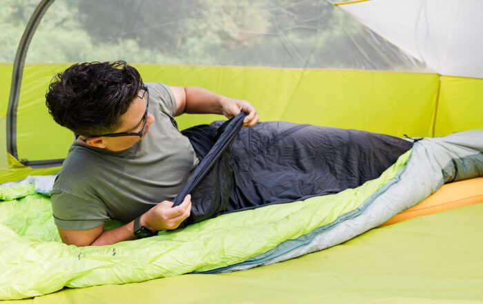 Person camping with Big Agnes sleeping bag and liner