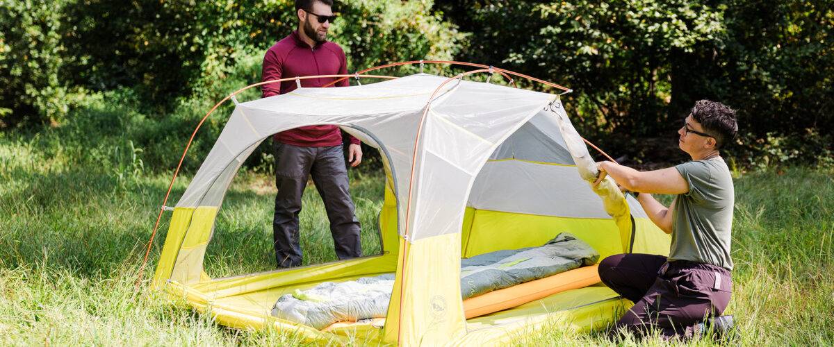 people setting up BIg Agnes tent outdoors
